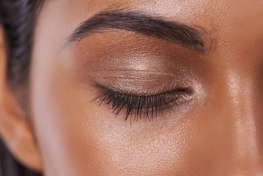 A close up of half of a woman's face focused on her shaped eyebrow.