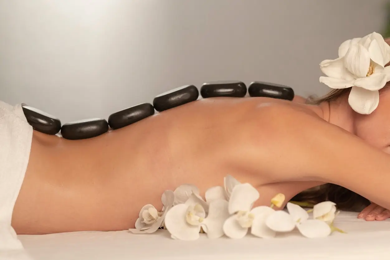 Woman on massage table with stones on her back.
